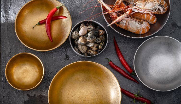 Close-up of Fine2Dine’s Host collection – glossy, double-walled stainless steel bowls designed for heat insulation and elegant food presentation.