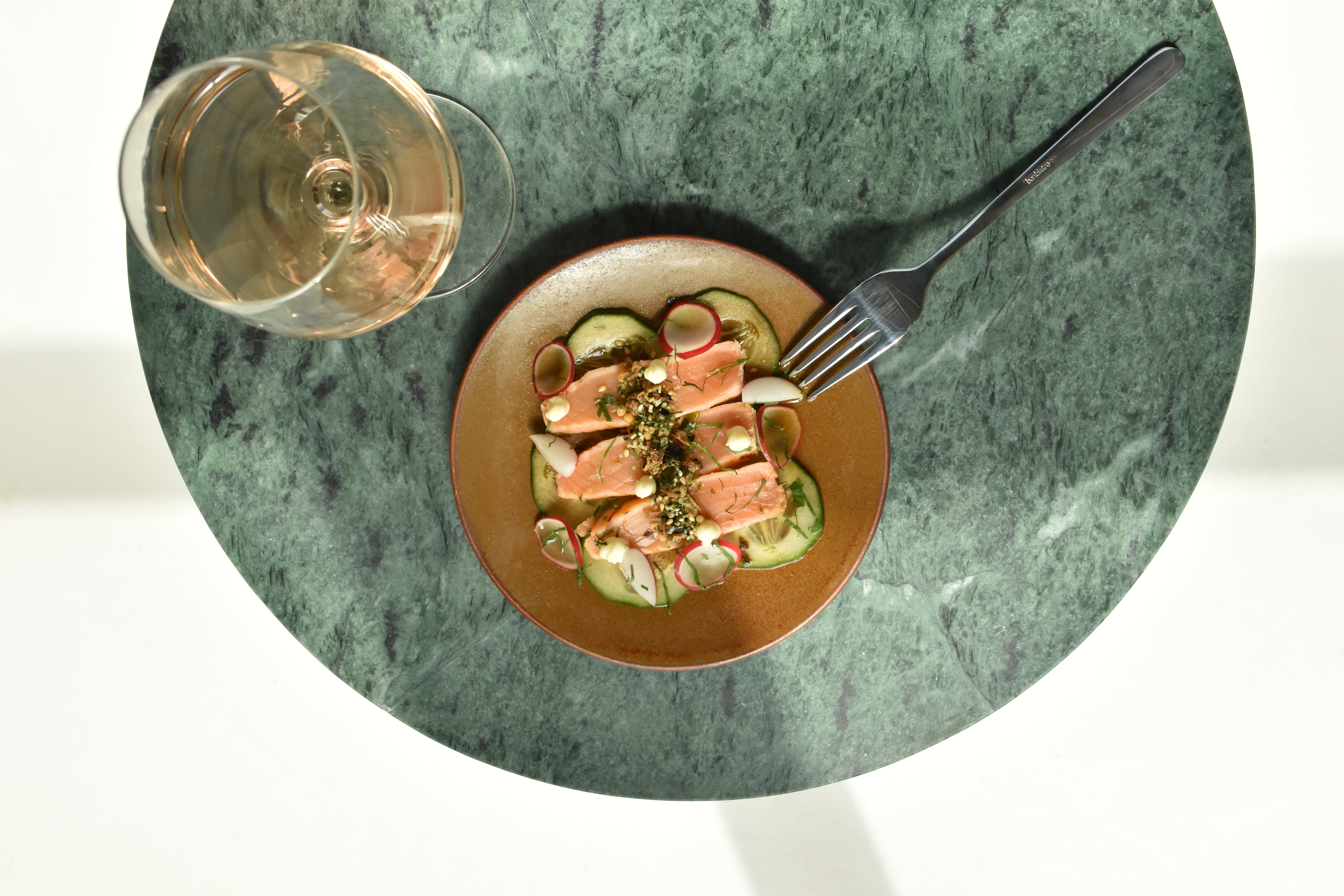 De Ovio-borden presenteren de zalm tataki in stijl, een verfijnde visgerecht gepresenteerd op een elegant porseleinen bord.